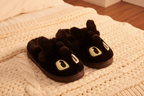 Black dragon slippers on soft blanket